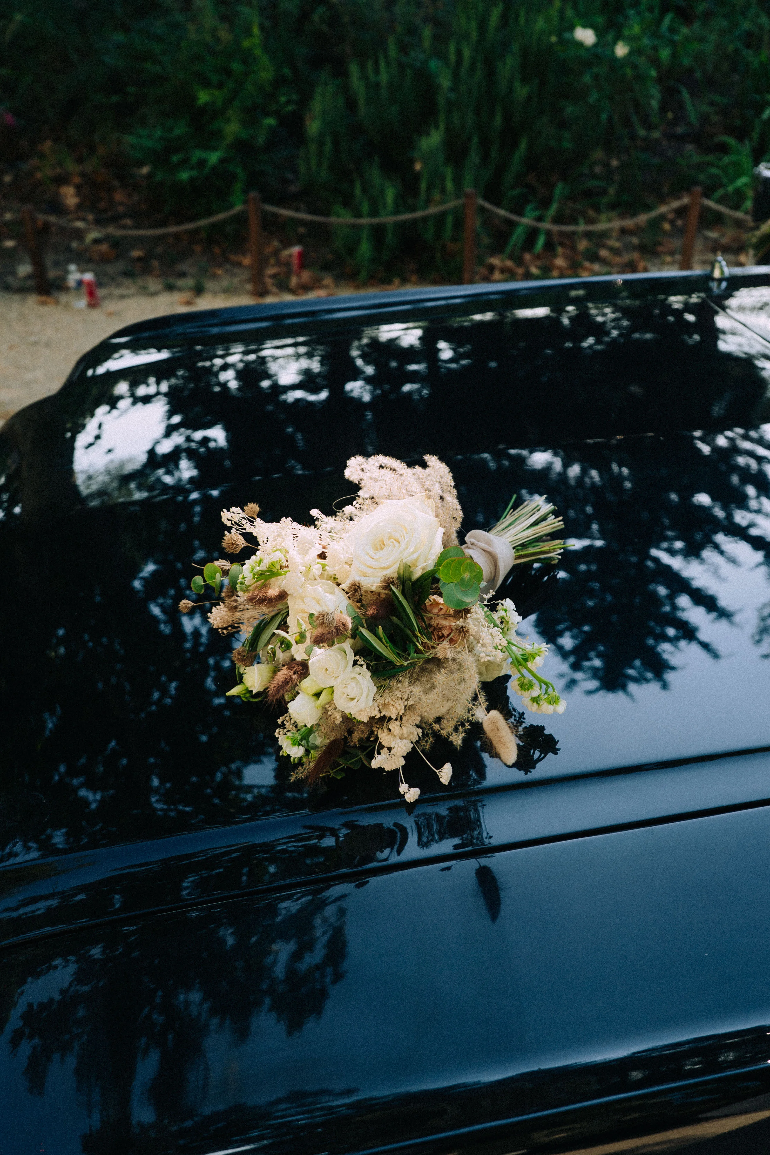 Bouquet de mariage posé sur une voiture ancienne