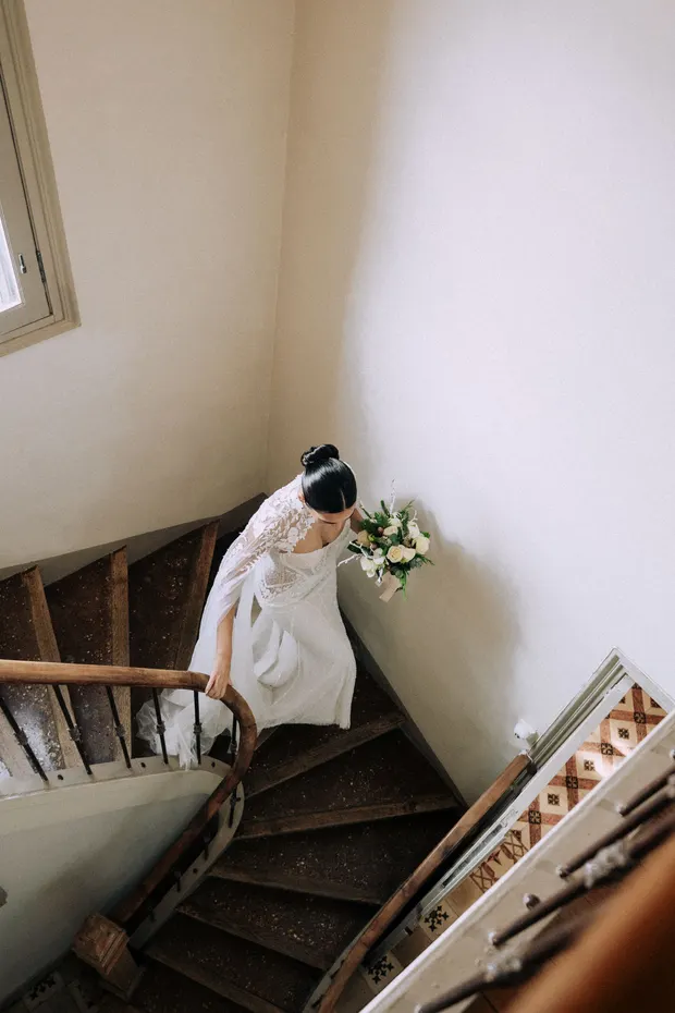 Caroline descend un escalier avec son bouquet au Domaine Tour des Chênes