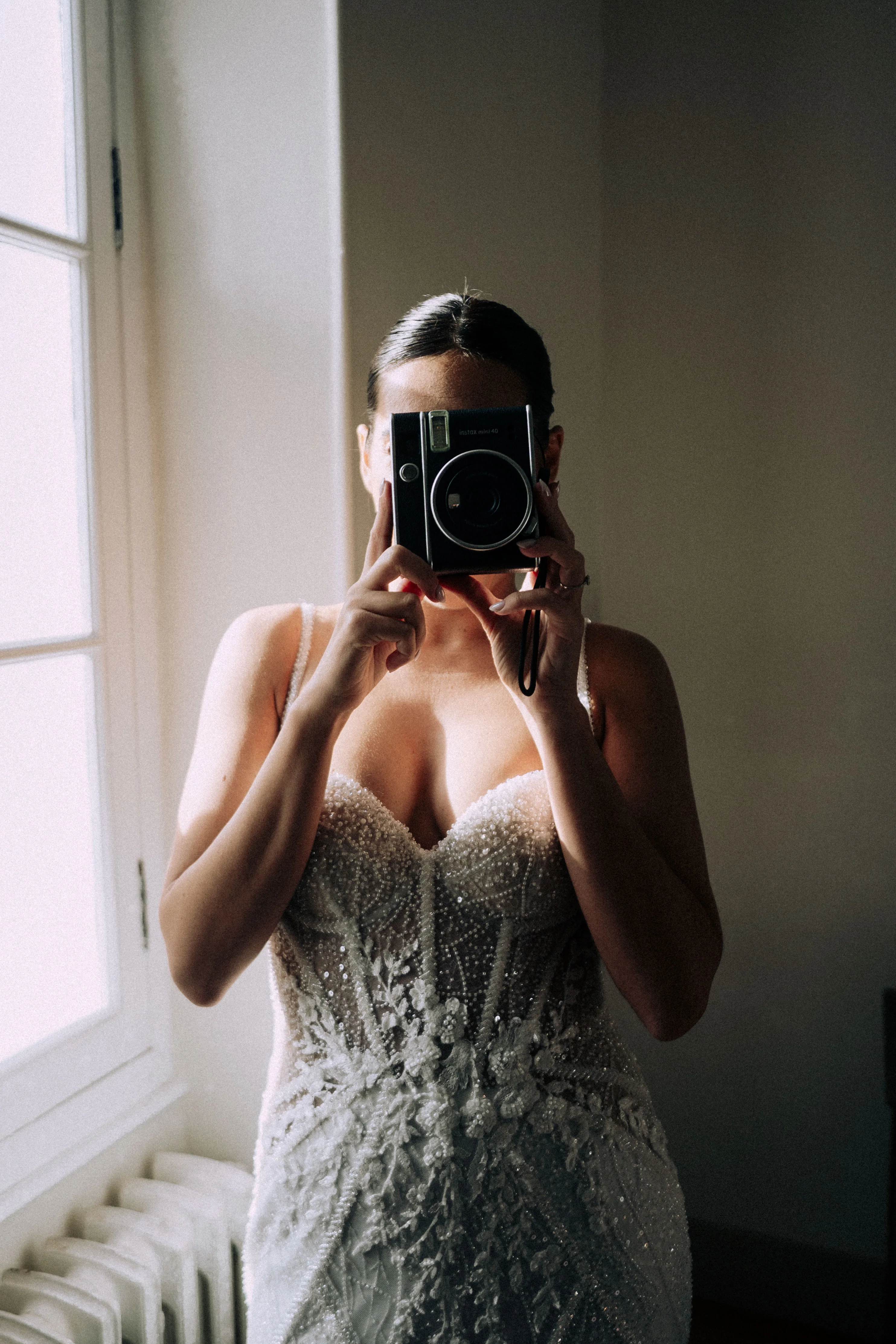 Caroline dans sa robe de mariée face au miroir, lumière intérieure éditoriale