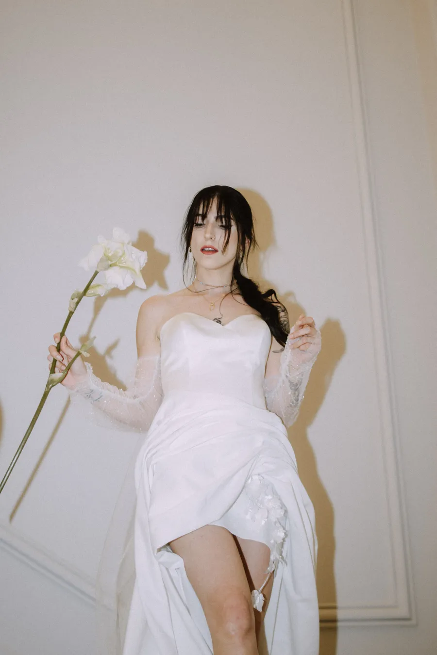 Portrait éditorial de Claire en robe de mariée avec orchidées au Château des 3 Fontaines
