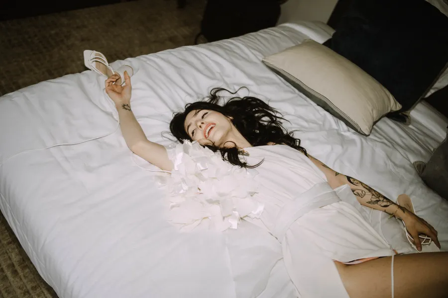 Claire allongée sur un lit pendant le shooting inspiration mariage